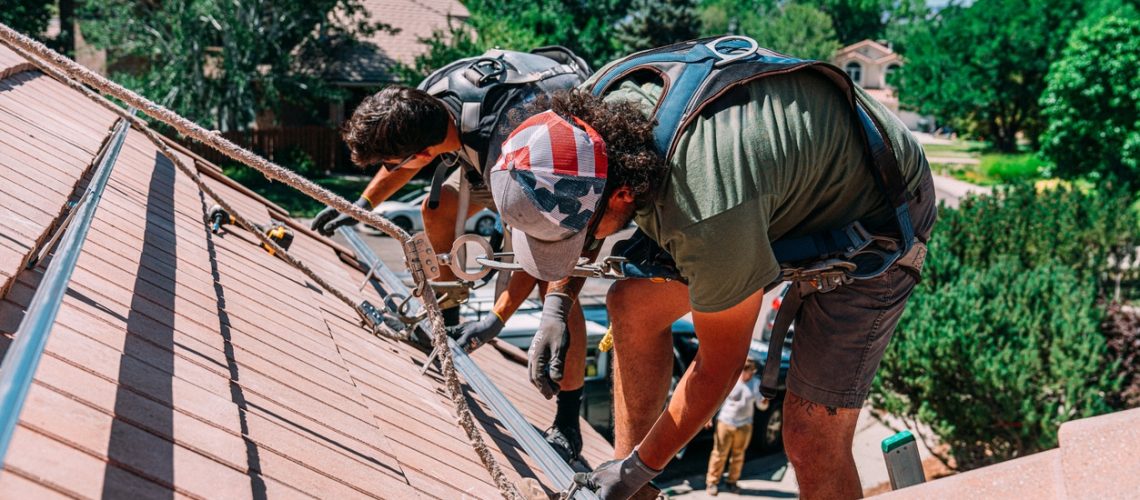 Professional Solar Installation Company Preparing a Clay Roof for Solar Panels on a Suburban Home with Clay Tiles in the Summer