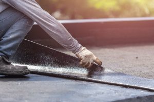 Group of worker installing tar foil on the rooftop of building. Waterproof system by gas and fire torching Group of worker installing tar foil on the rooftop of building. Waterproof system by gas and fire torching